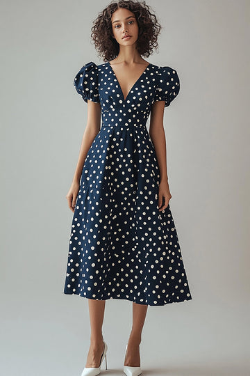 Une robe à pois blancs marine à col en V avec manches bouffantes